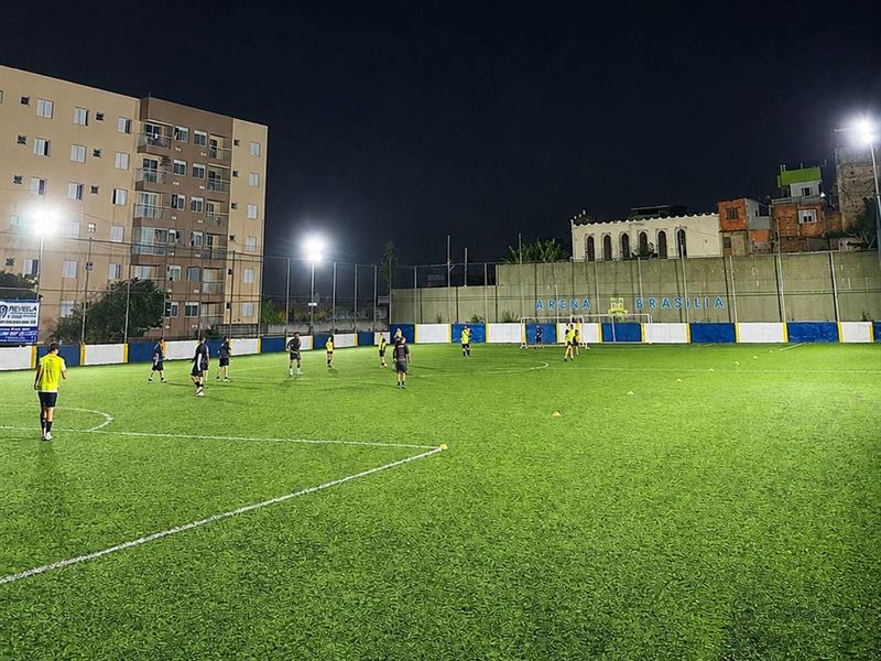 Campo da Arena Brasília à noite, iluminado pelos refletores, com jogadores em campo